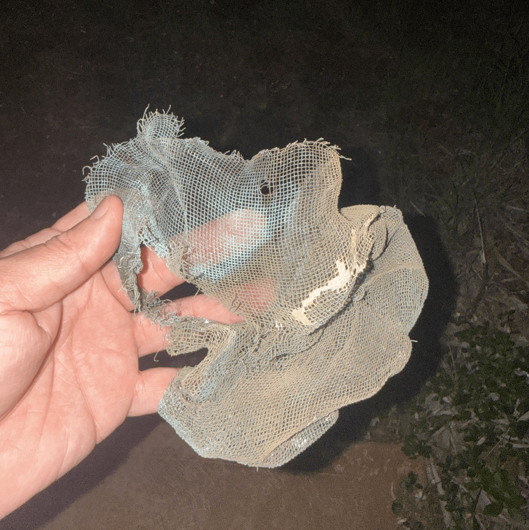 A ball of metal mesh with burnt paint on the ground right outside the vent